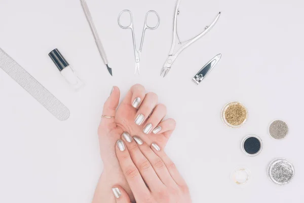 Cropped image of female hands with silver nail polish isolated on white — Stock Photo