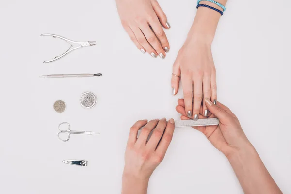 Abgeschnittenes Bild von Maniküre Feilen Nägel an Kunden mit Nagelfeile isoliert auf weiß — Stockfoto