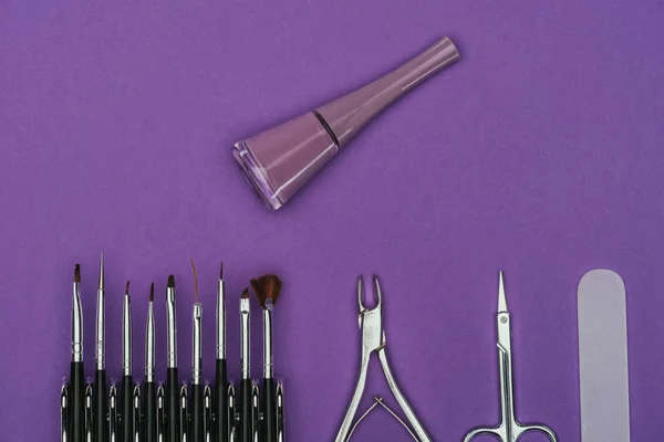 Top view of nail polish and manicure tools isolated on purple — Stock Photo