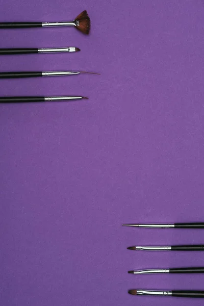Top view of rows of brushes isolated on purple — Stock Photo