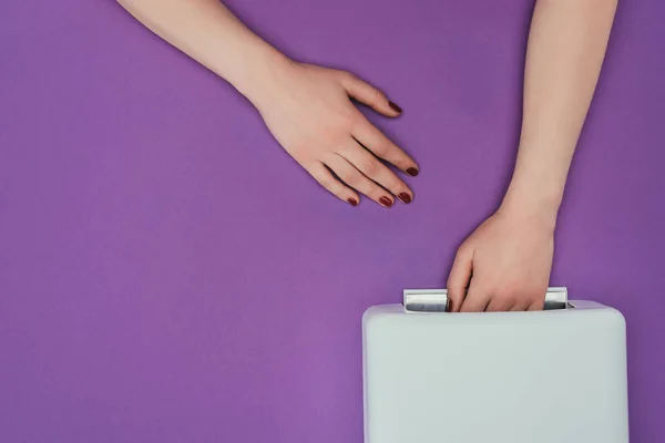 Immagine ritagliata della donna che tiene la mano in lampada UV isolata su viola — Foto stock