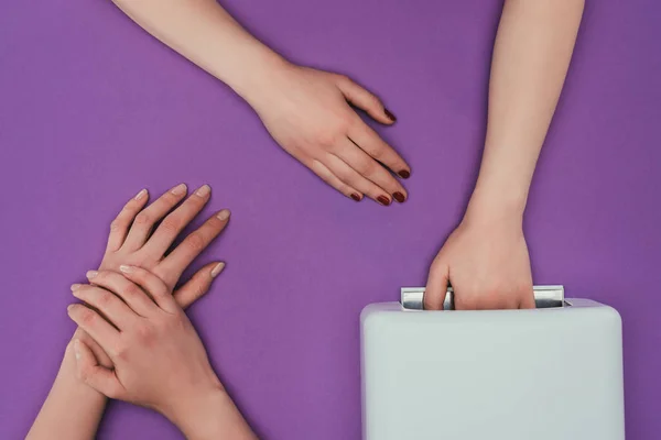 Immagine ritagliata del cliente che tiene la mano in lampada UV isolata su viola — Foto stock