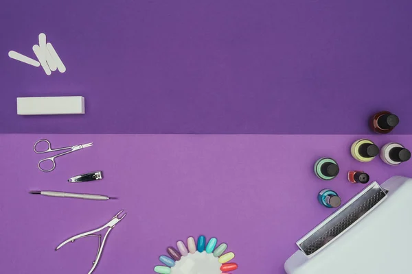 Top view of manicure tools and uv lamp on purple table — Stock Photo