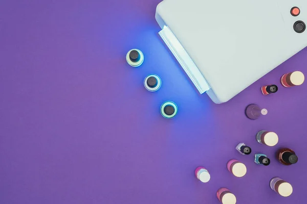 Top view of uv lamp light and nail polishes — Stock Photo