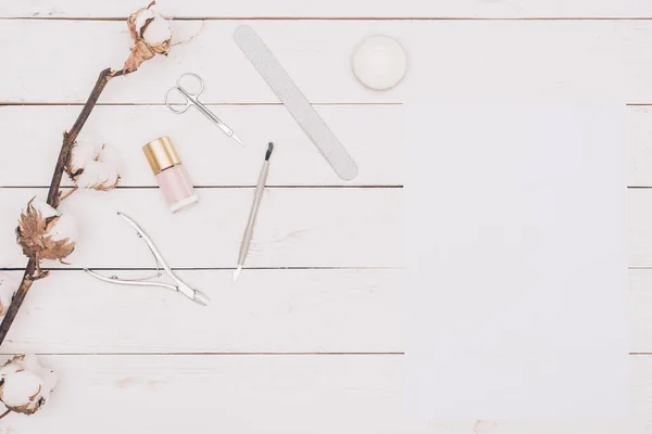 Vue de dessus des outils de manucure et du papier blanc sur table en bois — Photo de stock