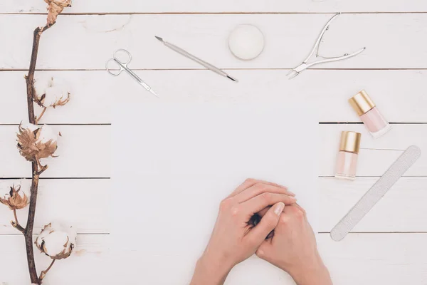 Image recadrée de la femme assise à table avec des outils de manucure — Photo de stock