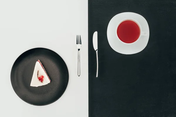 Top view of piece of cake on plate, cutlery and cup of tea — Stock Photo