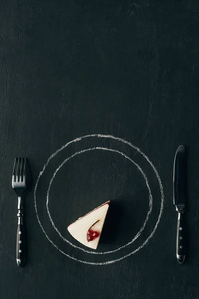 Top view of piece of cake and cutlery on black tabletop — Stock Photo
