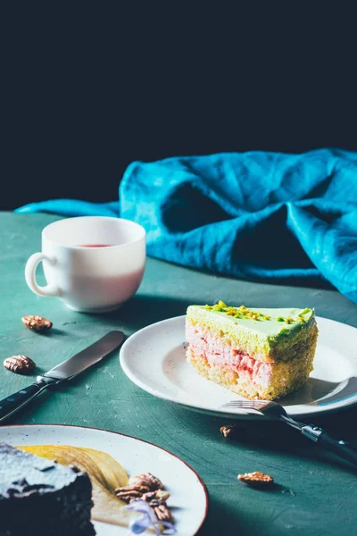 Nahaufnahme des Kuchenstücks auf Teller und Tasse Tee — Stockfoto