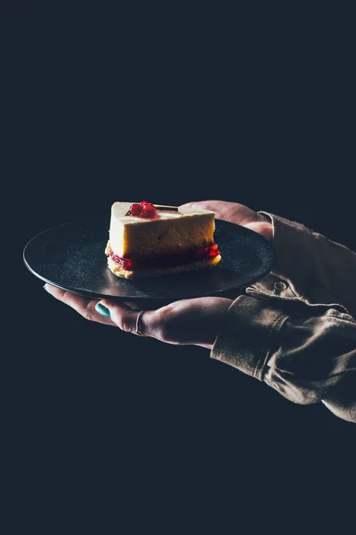 Close up view of woman holding piece of homemade cake on plate in hands — Stock Photo