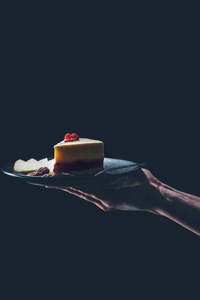 Close up view of woman holding piece of homemade cake on plate in hands — Stock Photo