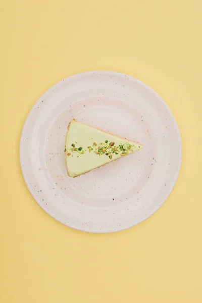Вид сверху кусок торта на тарелке изолирован на желтый — стоковое фото