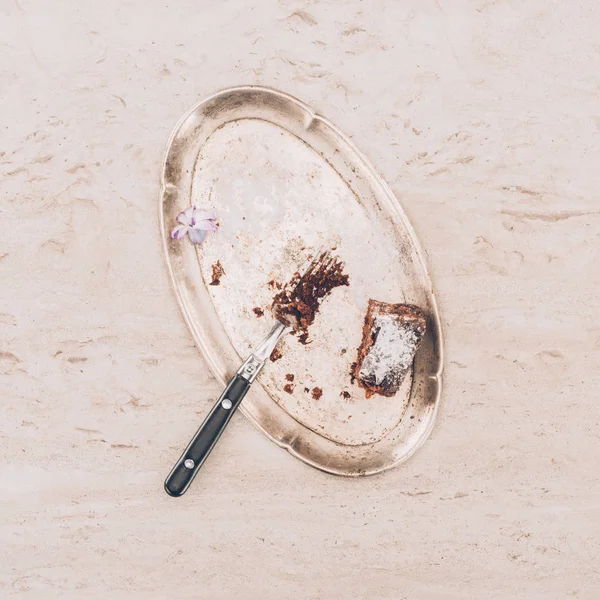 Close up view of fork with pieces of cake and antique tray in tabletop — Stock Photo