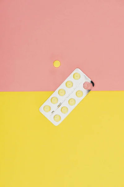 Вид зверху таблетки ізольовані на рожевому і жовтому тлі — стокове фото