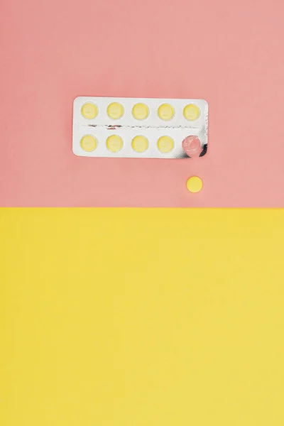 Vue du dessus des pilules isolées sur fond rose et jaune — Photo de stock