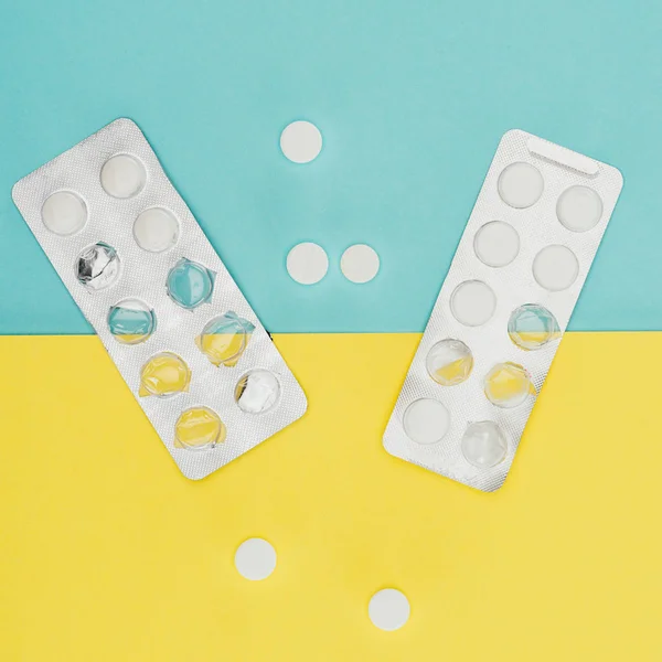 Top view of medicines isolated on blue and yellow background — Stock Photo