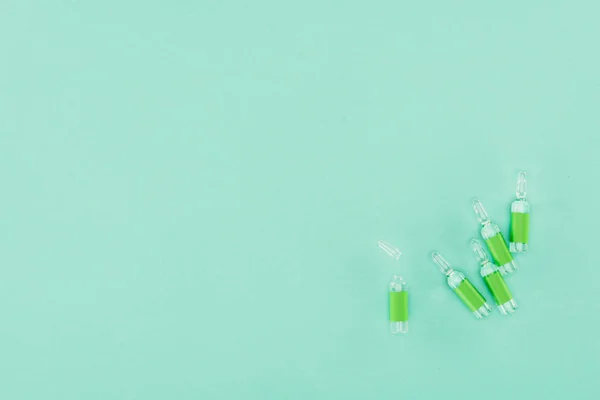 Top view of arranged ampules isolated on green — Stock Photo