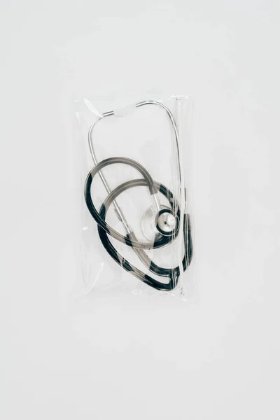 Vue rapprochée du stéthoscope médical emballé sur la table blanche — Photo de stock