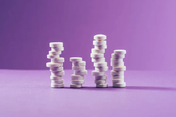 Close up view of arranged pills on purple background — Stock Photo