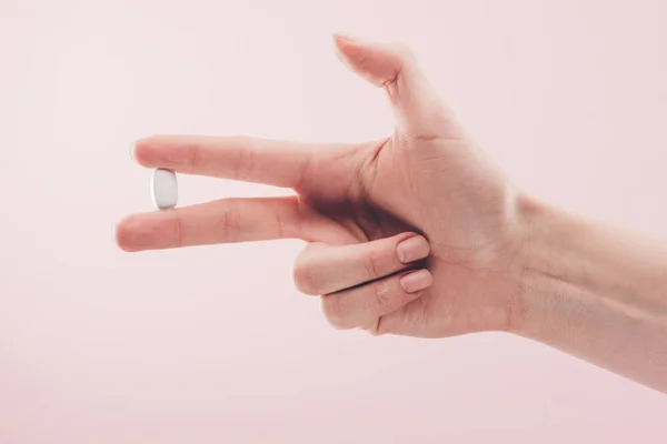 Vista parcial de la mujer que sostiene la medicina en la mano aislada en rosa - foto de stock