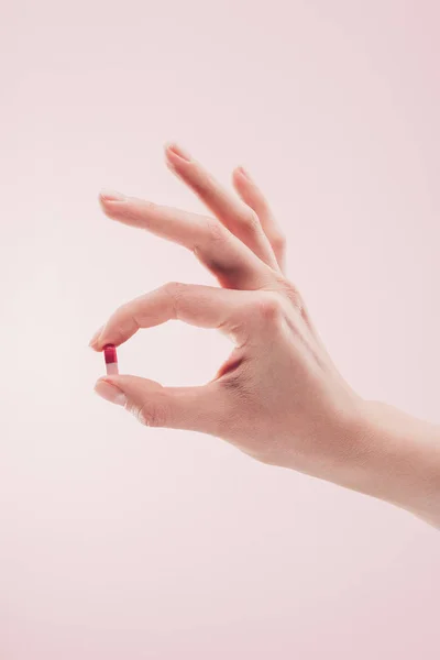 Частичное представление женщины, держащей в руке лекарство, изолированное на розовом — стоковое фото
