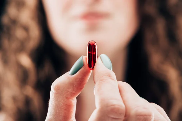 Vista parziale della donna che mostra pillola in mano — Foto stock