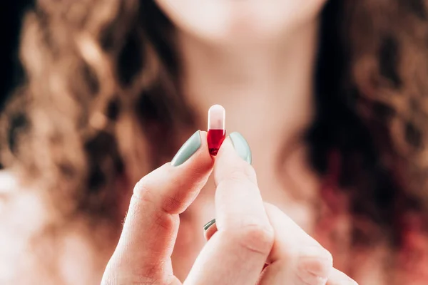 Visão parcial da mulher mostrando pílula na mão — Fotografia de Stock