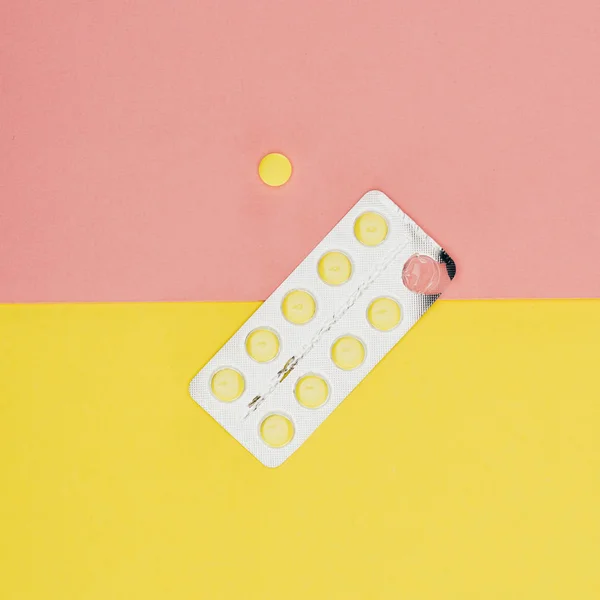 Top view of pills isolated on pink and yellow background — Stock Photo