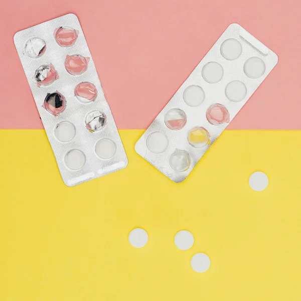 Vista dall'alto di pillole isolate su sfondo rosa e giallo — Foto stock