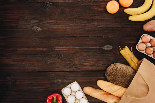 Vista superior de pão com ovos e vegetais com frutas na mesa de madeira — Fotografia de Stock