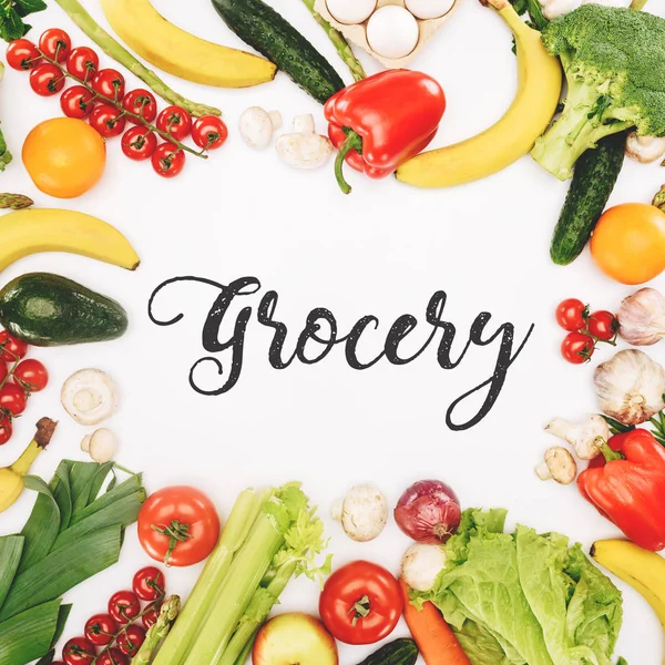 Vista superior de la palabra tienda de comestibles entre verduras y frutas aisladas en blanco - foto de stock