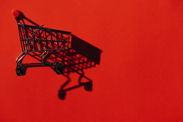 Ein Einkaufswagen mit Schatten an roter Wand — Stockfoto