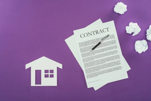 Vista superior del contrato comercial con la pluma y el símbolo de la casa en la superficie púrpura — Stock Photo