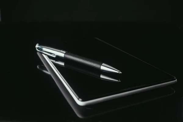 Primer plano de la tableta digital con pluma en la superficie negra - foto de stock