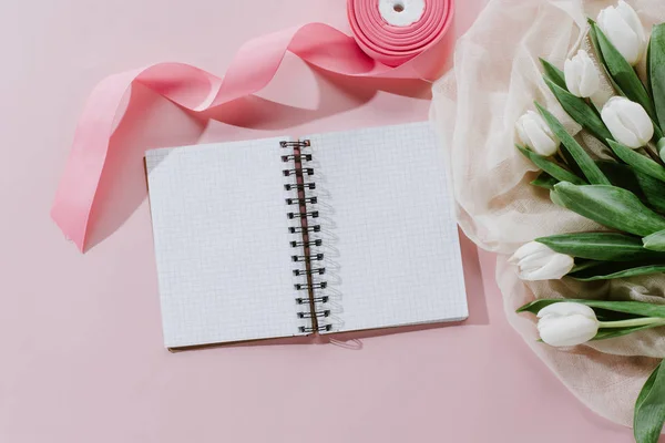 Vista superior do bloco de notas, fita rosa e tulipas brancas para o dia internacional das mulheres — Fotografia de Stock