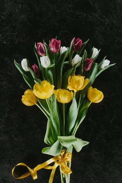 Vista dall'alto di bouquet con tulipani su superficie nera per 8 marzo — Foto stock