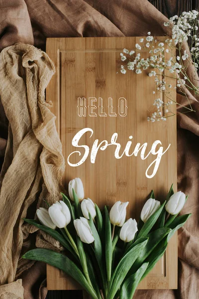 Vue de dessus des tulipes blanches sur la planche en bois avec lettrage de printemps bonjour — Photo de stock