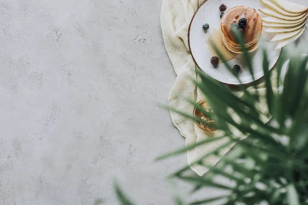 Selective focus of tasty homemade pancakes with honey and berries on grey — Stock Photo