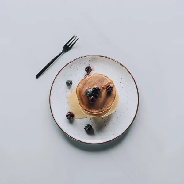 Top view of sweet tasty pancakes with fresh healthy berries on grey — Stock Photo