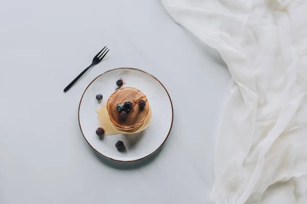 Blick von oben auf leckere Pfannkuchen mit frischen gesunden Beeren auf grau — Stockfoto