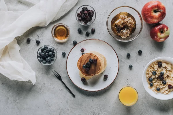 Vista dall'alto di colazione sana con frittelle fatte in casa, frutta fresca e miele sul grigio — Foto stock