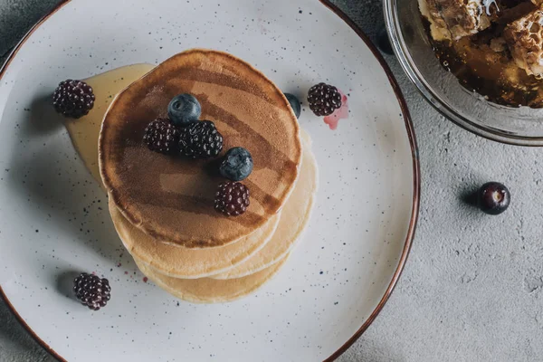 Von oben auf süße hausgemachte Pfannkuchen mit frischen Beeren und Honig — Stockfoto