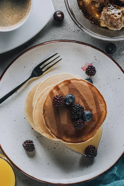 Von oben auf süße hausgemachte Pfannkuchen mit Beeren und Honig — Stockfoto