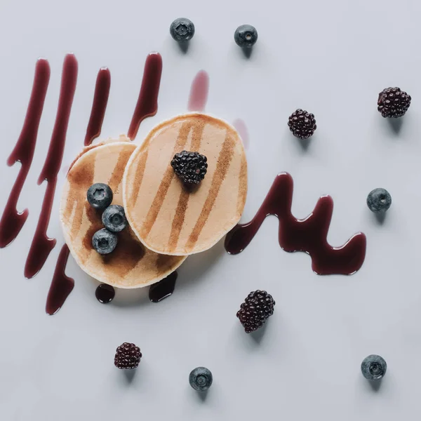 Top view of sweet gourmet pancakes with fresh berries and jam on grey — Stock Photo