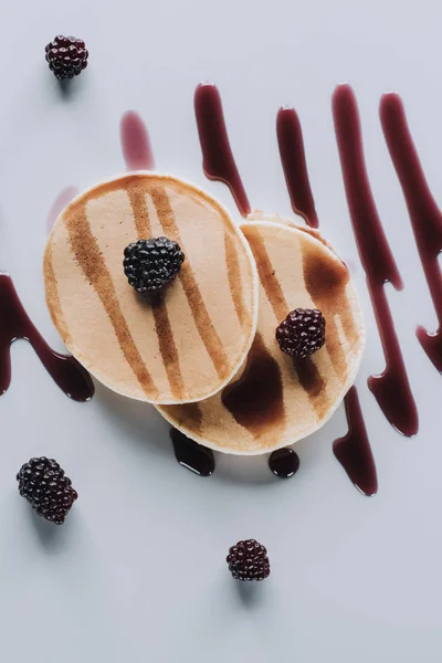 Top view of sweet gourmet pancakes with fresh blackberries and jam on grey — Stock Photo