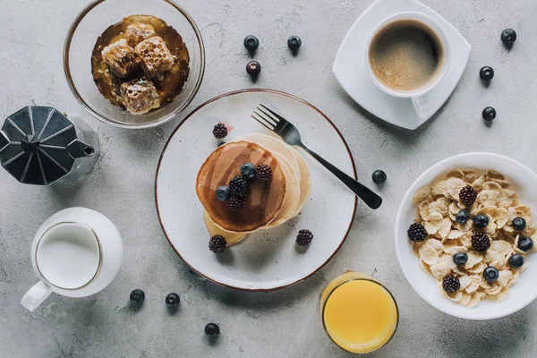 Top view of tasty healthy breakfast with pancakes and muesli on grey — Stock Photo