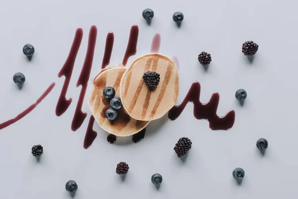Von oben auf süße hausgemachte Pfannkuchen mit frischen Beeren und Marmelade auf grau — Stockfoto