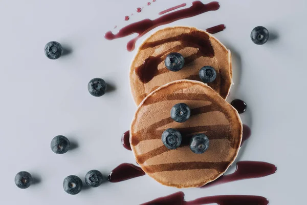 Vue de dessus de délicieuses crêpes maison sucrées aux bleuets frais et confiture sur gris — Photo de stock