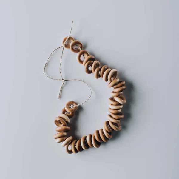 Top view of tasty bagels on rope isolated on grey — Stock Photo