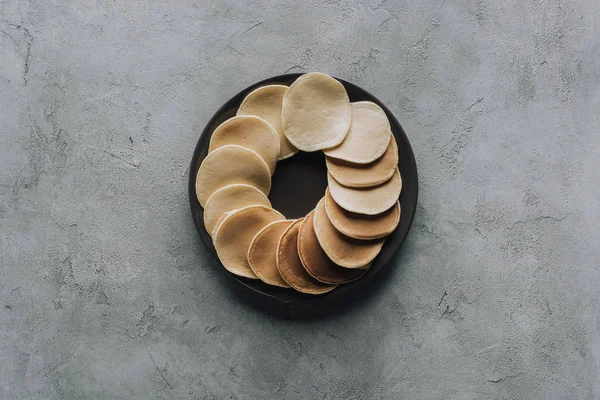 Vue de dessus des crêpes maison savoureuses sur assiette sur gris — Photo de stock